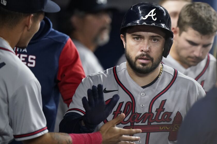 Atlanta Braves' Travis d'Arnaud is congratulated by teammates after he scored on a single by William Contreras during the fifth inning of a baseball game against the Miami Marlins, Tuesday, Oct. 4, 2022, in Miami. (AP Photo/Wilfredo Lee)
