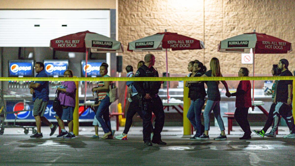Customers are escorted from a Costco store in Corona after Friday night's shooting involving an off-duty LAPD officer.