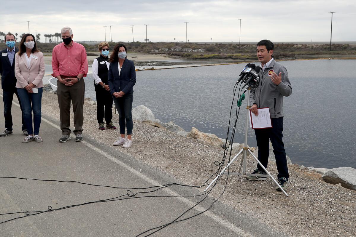 State Sen. Dave Min, right, speaks during a press conference on Wednesday at Talbert Marsh in Huntington Beach.