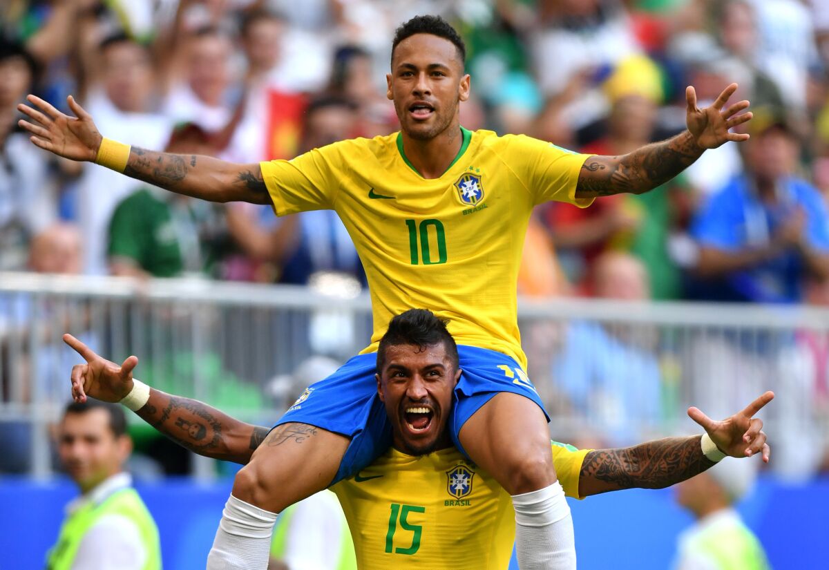 Brazil's Neymar, top, celebrates with teammate Paulinho after scoring his team's first goal against Mexico in Samara, Russia, on Monday.