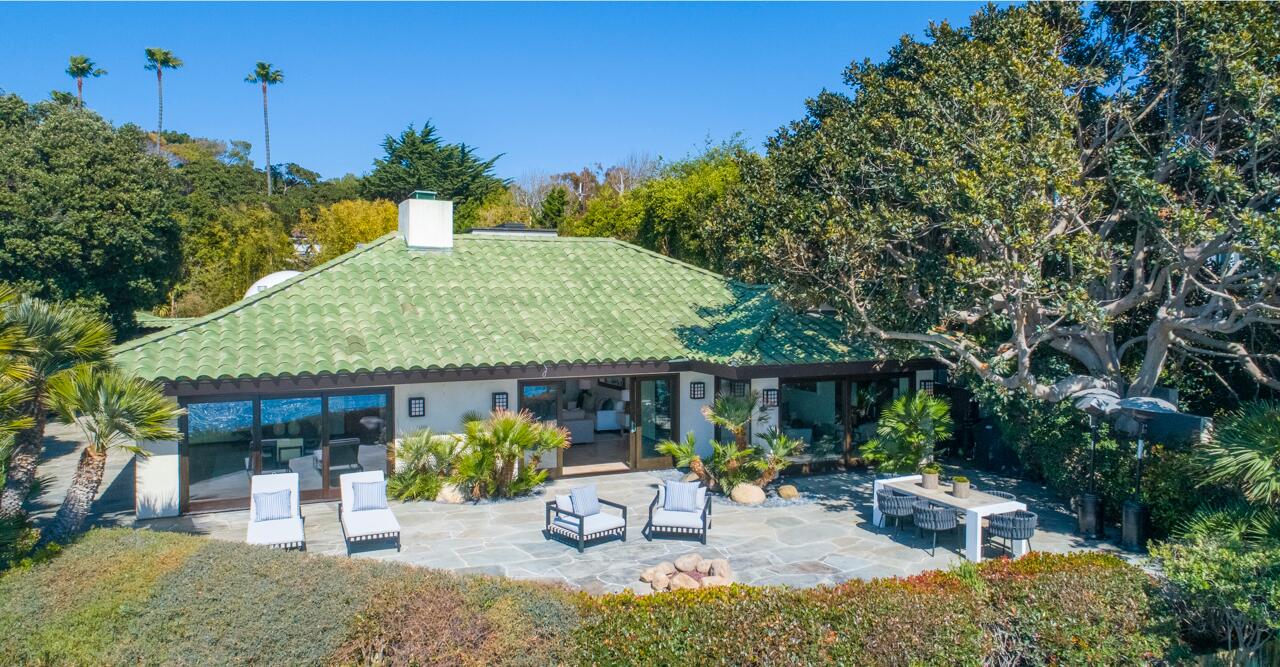 Overlooking the ocean, the one-acre grounds include two structures: a main house with a screening room and a guesthouse with a gym.