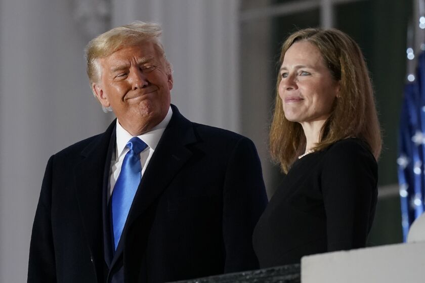 President Donald Trump and Amy Coney Barrett stand on the Blue Room Balcony after Supreme Court Justice Clarence Thomas administered the Constitutional Oath to her on the South Lawn of the White House White House in Washington, Monday, Oct. 26, 2020. Barrett was confirmed to be a Supreme Court justice by the Senate earlier in the evening. (AP Photo/Patrick Semansky)
