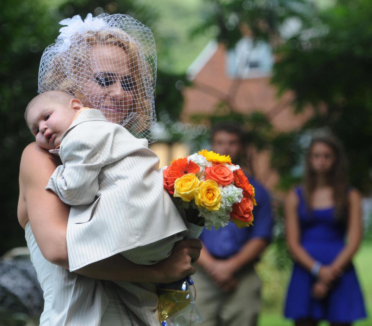 Christine Swidorsky carries her son and the couple's best man, Logan Stevenson, 2, down the aisle to her husband-to-be Sean Stevenson during the wedding ceremony in Jeannette, Pa. Christine Swidorsky Stevenson says on her Facebook page that Logan died in her arms at 8:18 p.m. Monday, Aug. 5, 2013, at their home in Jeannette, about 25 miles east of Pittsburgh.