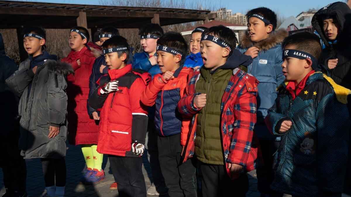 Boys pledge and chant before stripping to the waist for a run through a freezing Beijing park.