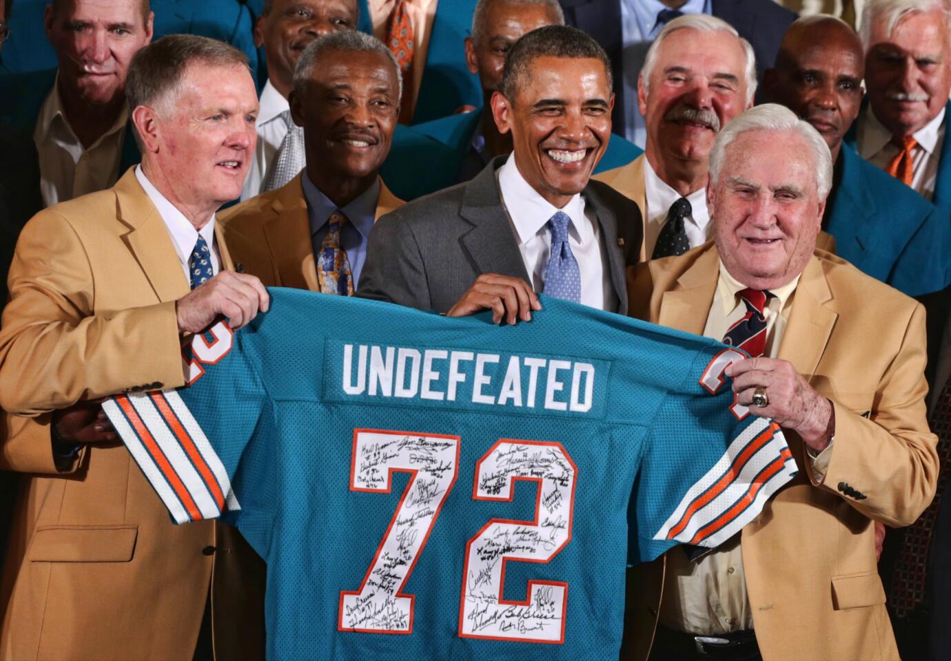 First row, President Barack Obama poses for photos with members of the 1972 Miami Dolphins including head coach Don Shula (R), quarterback Bob Griese (L), and running back Larry Csonka (4th L) during an East Room event August 20, 2013 at the White House in Washington, DC. President Obama hosted the undefeated 1972 Super Bowl champion who didnt get the chance to be honored at the White House back then.