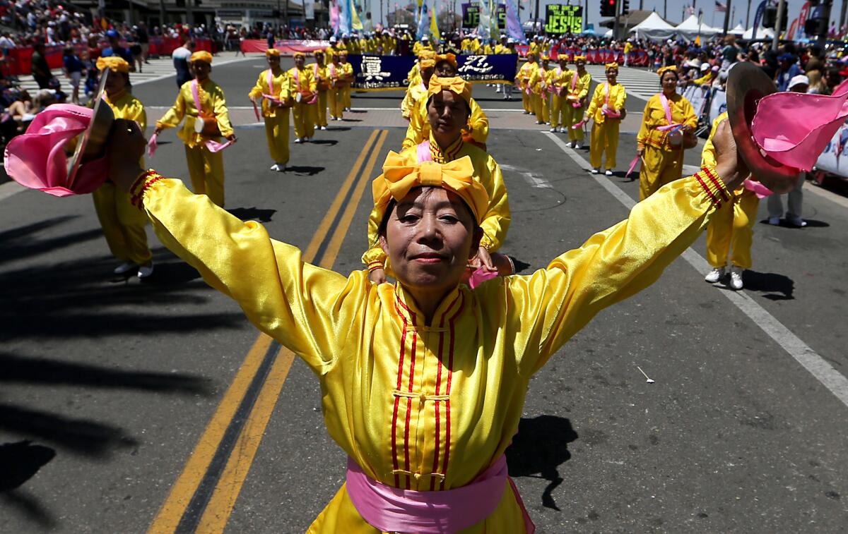 People in yellow and red outfits perform during a parade