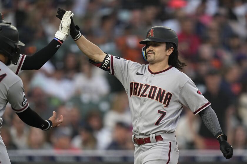Arizona Diamondbacks' Corbin Carroll is greeted at home plate after his grand slam during the seventh inning of a baseball game against the Detroit Tigers, Friday, June 9, 2023, in Detroit. (AP Photo/Carlos Osorio)