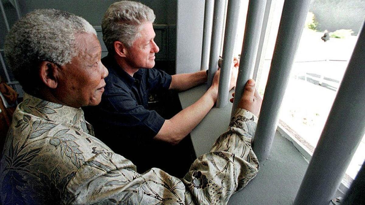 Presidents Mandela and Clinton look out from a cell on Robben Island in Cape Town's Table Bay in 1998. Mandela spent 18 of his 27 years in this prison cell during apartheid.
