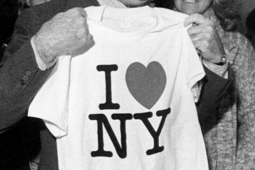 New York Gov. Hugh Carey holds up an "I Love New York" t-shirt in 1977.