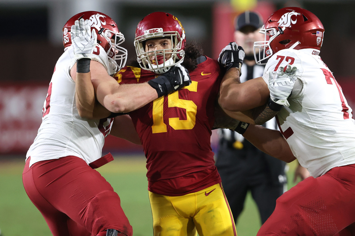 Washington State offensive linemen Abraham Lucas, right, and Josh Watson try to block USC's Talanoa Hufanga.