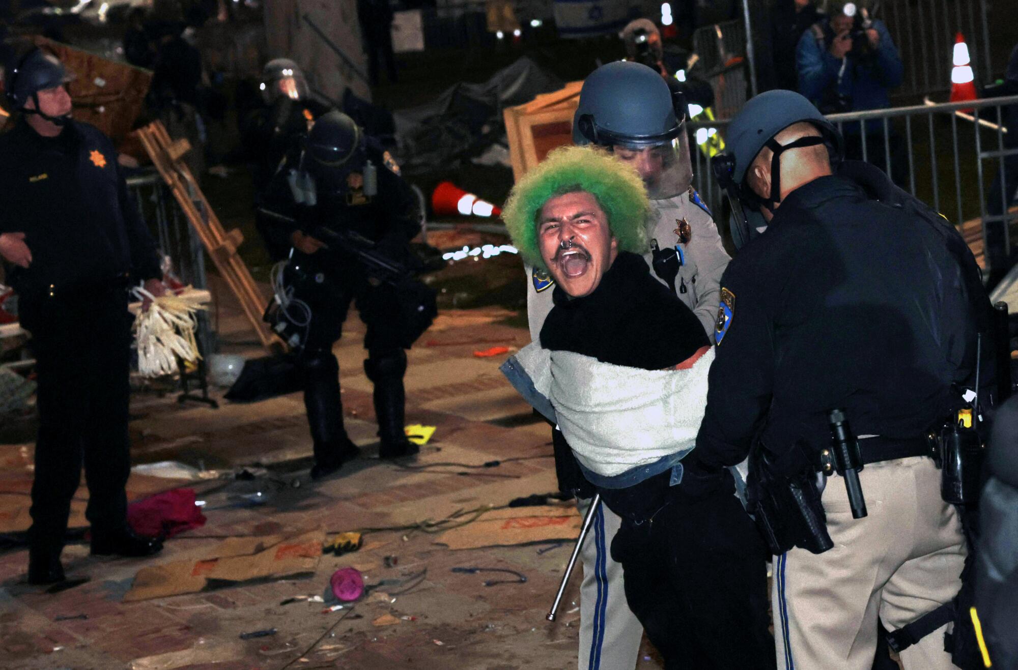 Los agentes de policía arrestaron a un manifestante pro palestino después de que se le ordenara dispersarse en UCLA el jueves por la mañana temprano.