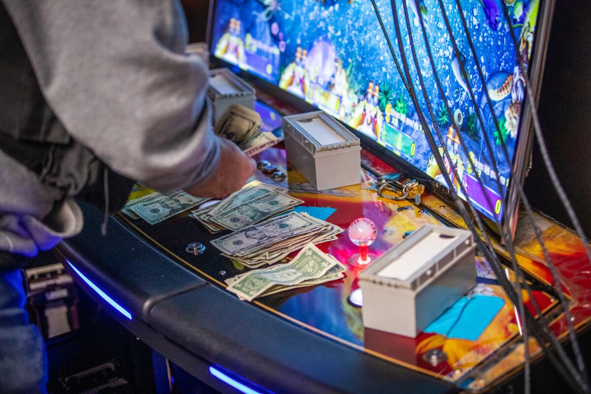 A man counts money at a gambling machine