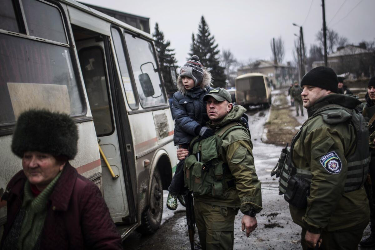 A Ukrainian soldier assists with the evacuation of civilians from Debaltseve in the Donetsk region of eastern Ukraine on Feb. 3. The area has come under intense shelling in recent days and civilian deaths have soared.
