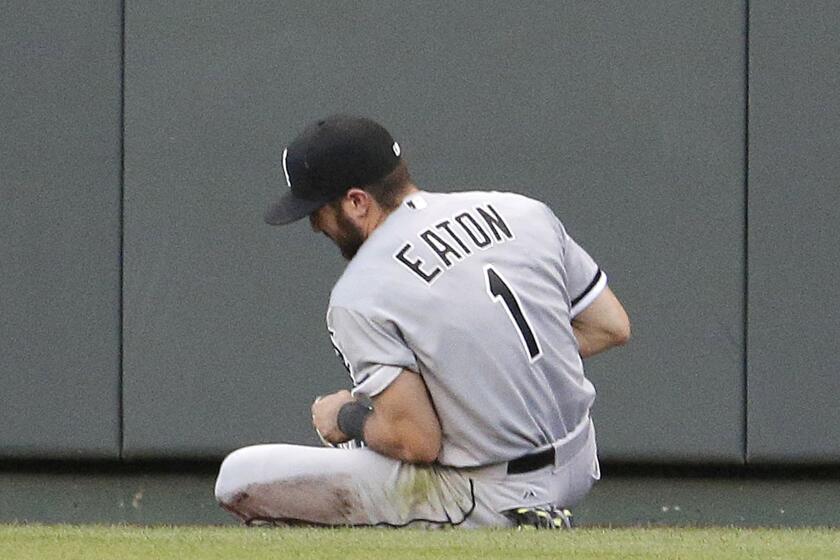 White Sox center fielder Adam Eaton sits on the warning track after catching a fly ball for the out against Kansas City Royals' Ben Zobrist during the fourth inning. Eaton came out of the game with an injury after the play.