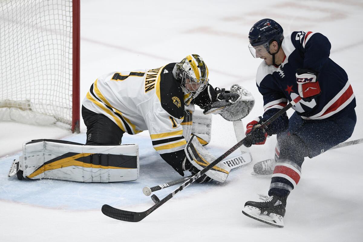 Boston Bruins goaltender Jeremy Swayman (1) defends against Washington Capitals right wing Garnet Hathaway, right, during the first period of an NHL hockey game Thursday, April 8, 2021, in Washington. (AP Photo/Nick Wass)
