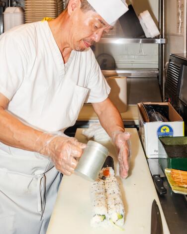 Bruce Lee sprinkles pepper on summer rolls at Kumi Ko.