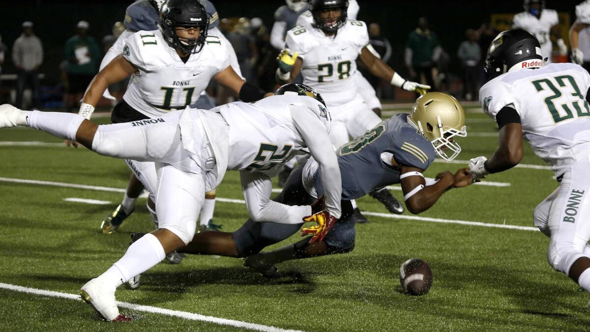 Long Beach Poly quarterback Nolan McDonald fumbles the ball, which was recovered by Narbonne linebacker Raymond Scott (22).