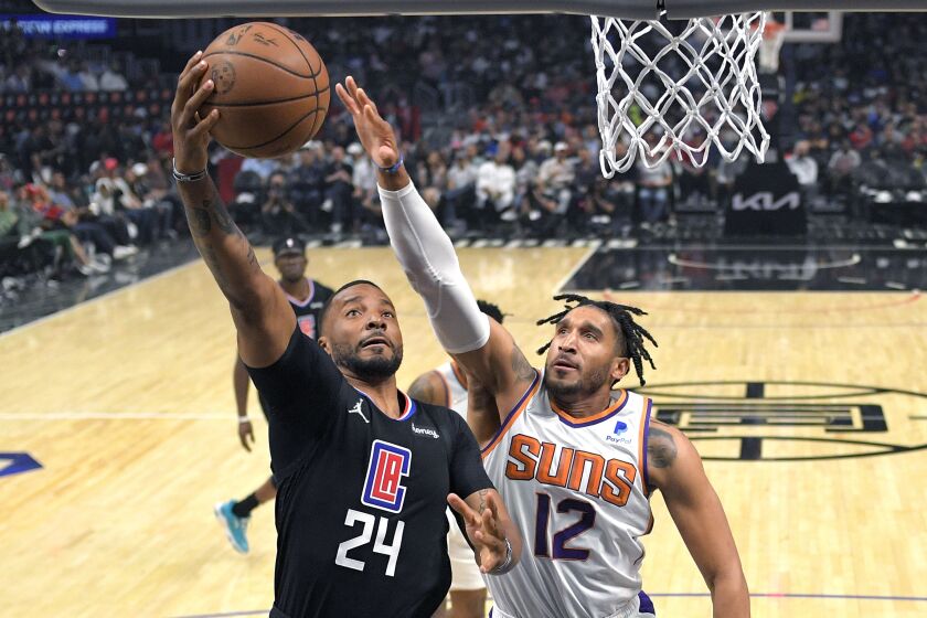 Los Angeles Clippers forward Norman Powell, left, shoots as Phoenix Suns forward Ish Wainright defends during the first half of an NBA basketball game Wednesday, April 6, 2022, in Los Angeles. (AP Photo/Mark J. Terrill)