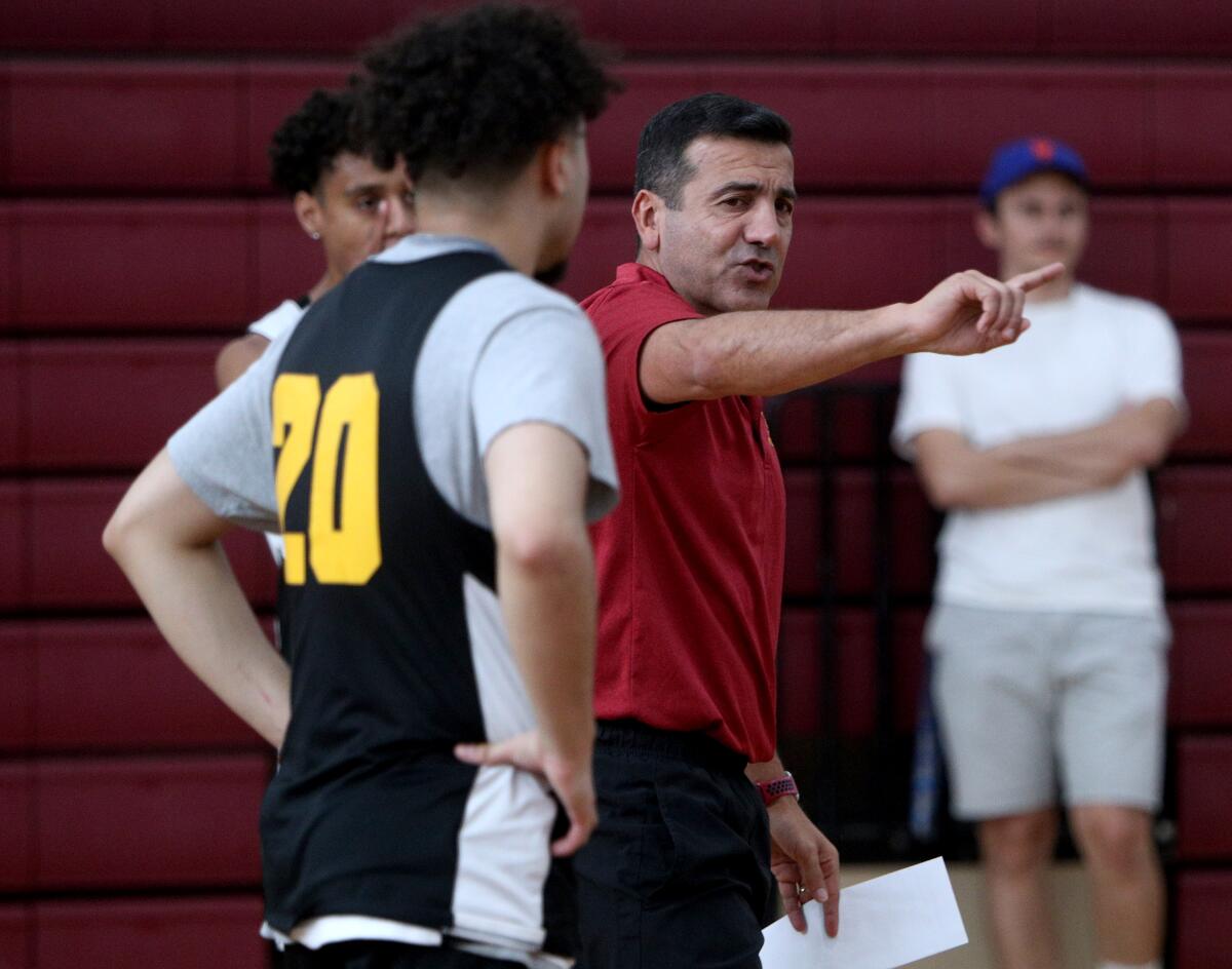 Glendale Community College men's basketball coach Vigen Jilizian goes over a drill with his players during a recent practice.