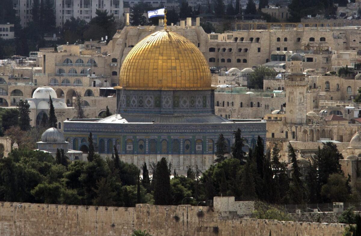 Seen from Mount Scopus, the distinctive golden Dome of the Rock, one of Islam's holiest sites, stands out in Jerusalem's walled Old City on Nov. 3. Behind it, a large Israeli flag flies atop an apartment building.