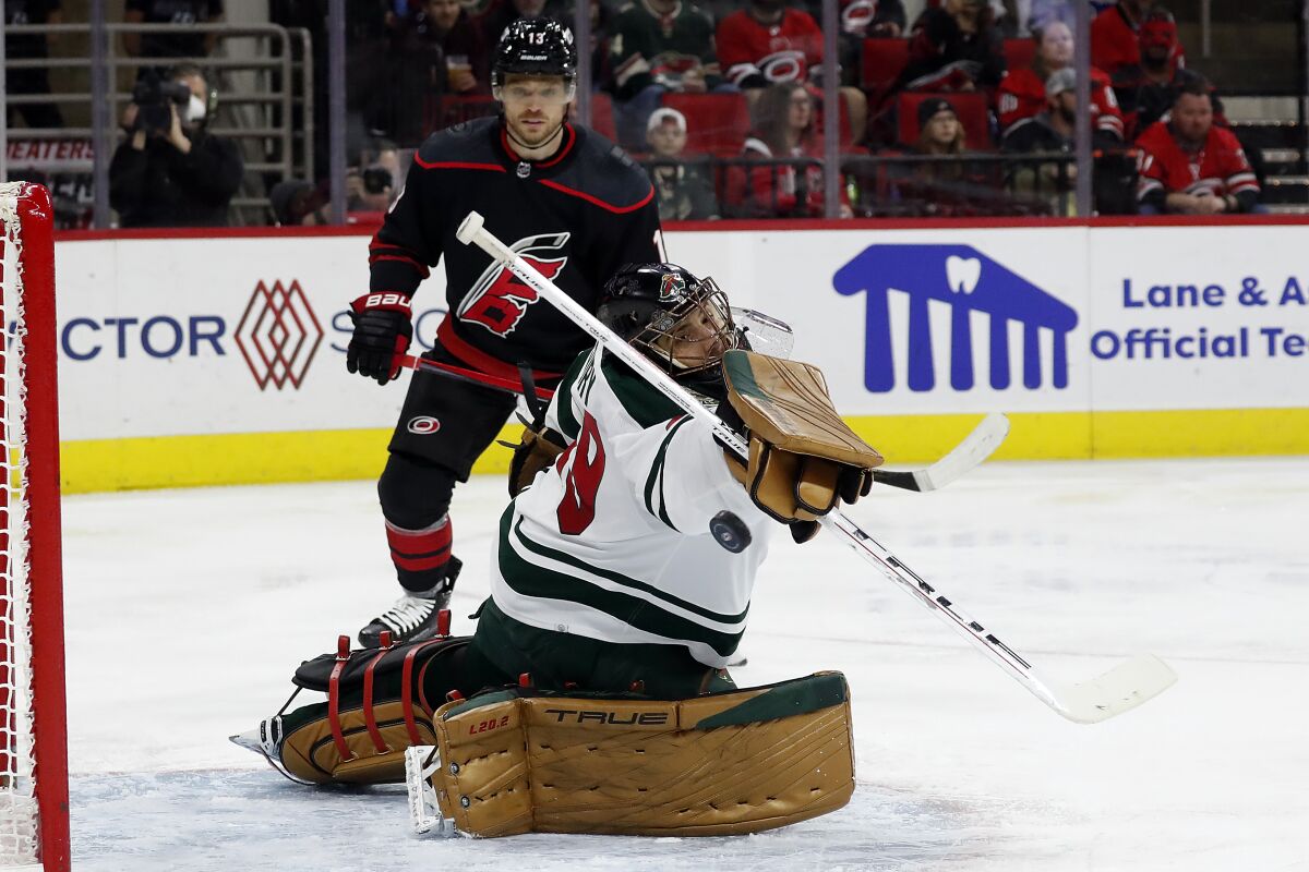 Minnesota Wild goaltender Marc-Andre Fleury (29) deflects a Carolina Hurricanes shot with Hurricanes' Max Domi (13) nearby during the second period of an NHL hockey game in Raleigh, N.C., Saturday, April 2, 2022. (AP Photo/Karl B DeBlaker)