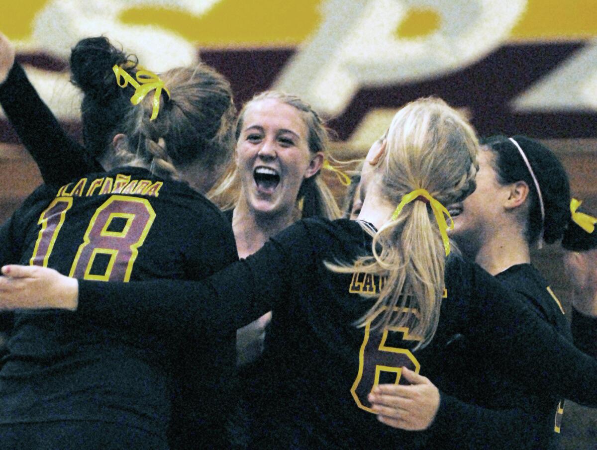 La Cañada’s Courtney McCutchan, center, celebrates with teammates Micaela Anderson and Katie Pierce during 2009 volleyball playoffs.