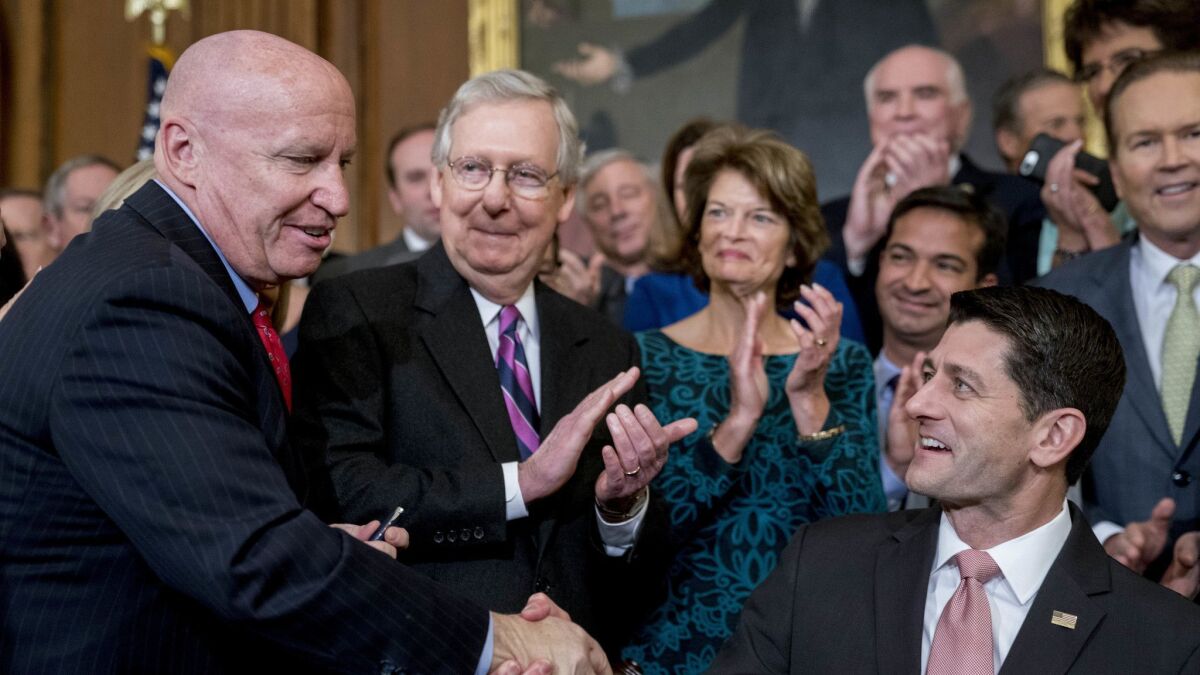 Republicans celebrated passage of the tax cuts last December: House Speaker Paul Ryan, R-Wis., right, shook hands with Ways and Means Committee Chairman Kevin Brady, R-Texas, as Senate Majority Leader Mitch McConnell, R-Ky., second from left, looked on.