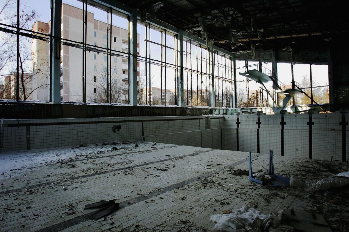 A pair of flippers lie in a swimming pool in an empty building.