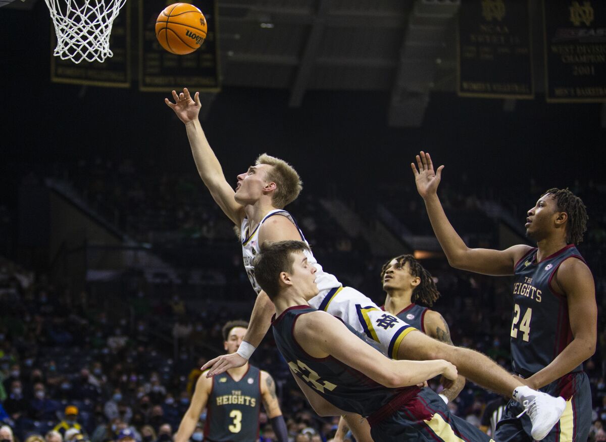 Notre Dame's Dane Goodwin (23) gets fouled by Boston College's Justin Vander Baan (32) during an NCAA college basketball game, Wednesday, Feb. 16, 2022 in South Bend, Ind. (Michael Caterina/South Bend Tribune via AP)