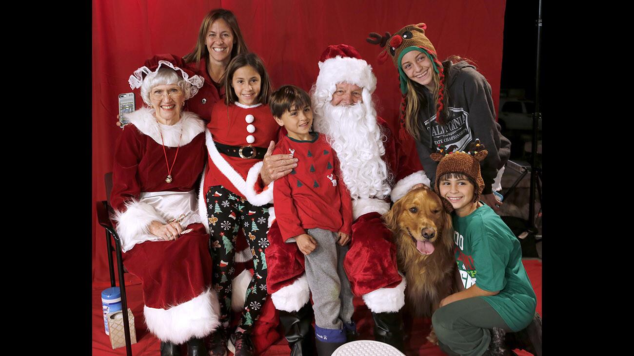 The Matarese family takes a photo with Santa Claus and Mrs. Claus during the 22nd annual Chamber of Commerce Festival in Lights, at Memorial Park in La Cañada Flintridge on Friday, Dec. 1, 2017. Kids enjoyed tons of snow along with live reindeer and songs from the local schools choral groups. The Matarese, from left to right are mom Christy, Katelyn, 11, Luca, 7, dog Cody, 4, Charley, 9, and Ellaney, 14.