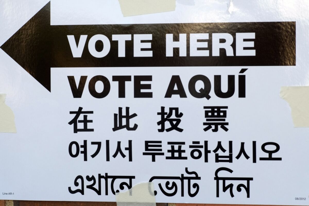 FILE - A sign is posted outside an election site in the Borough Park section of the Brooklyn borough of New York, Nov. 4, 2014. The sign reads "Vote Here" in English, Spanish, Chinese, Korean and Bengali. The number of people in jurisdictions requiring elections officials to provide voting materials in languages other than English jumped by almost a quarter over the past five years, reflecting the increasingly diverse electorate in the U.S., according to figures released Wednesday, Dec. 8, 2021 by the Census Bureau. (AP Photo/Mark Lennihan)