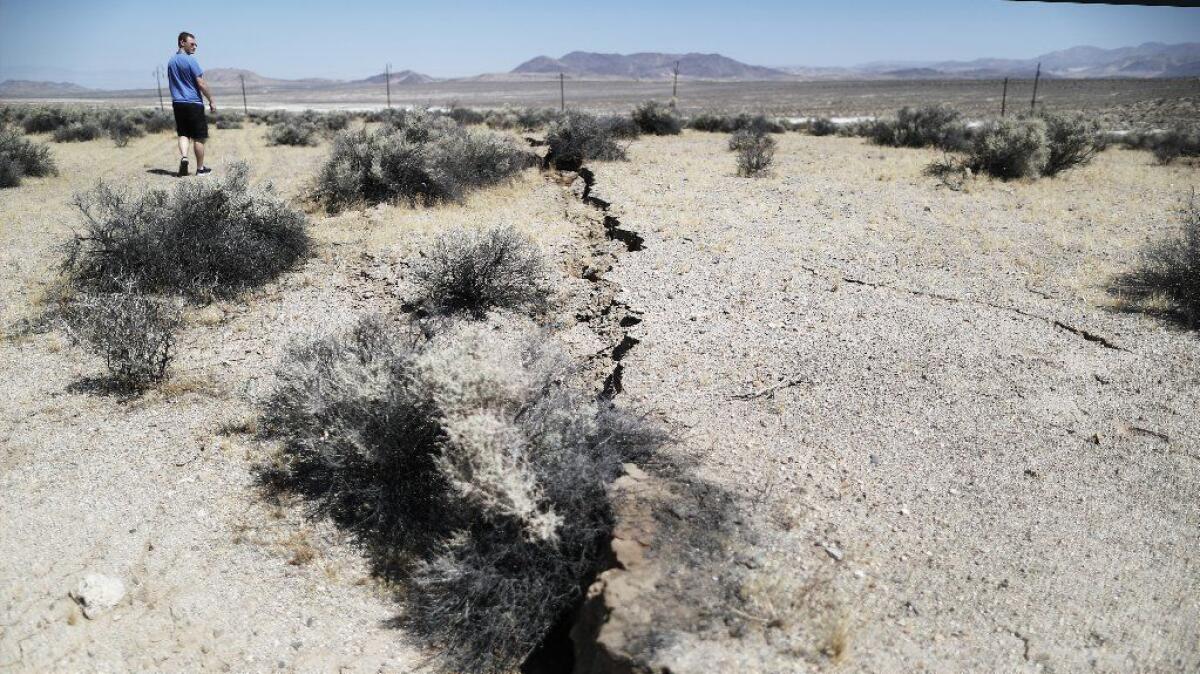 A visitor views ground ruptured in the magnitude 7.1 earthquake that struck near Ridgecrest, Calif., on July 5.