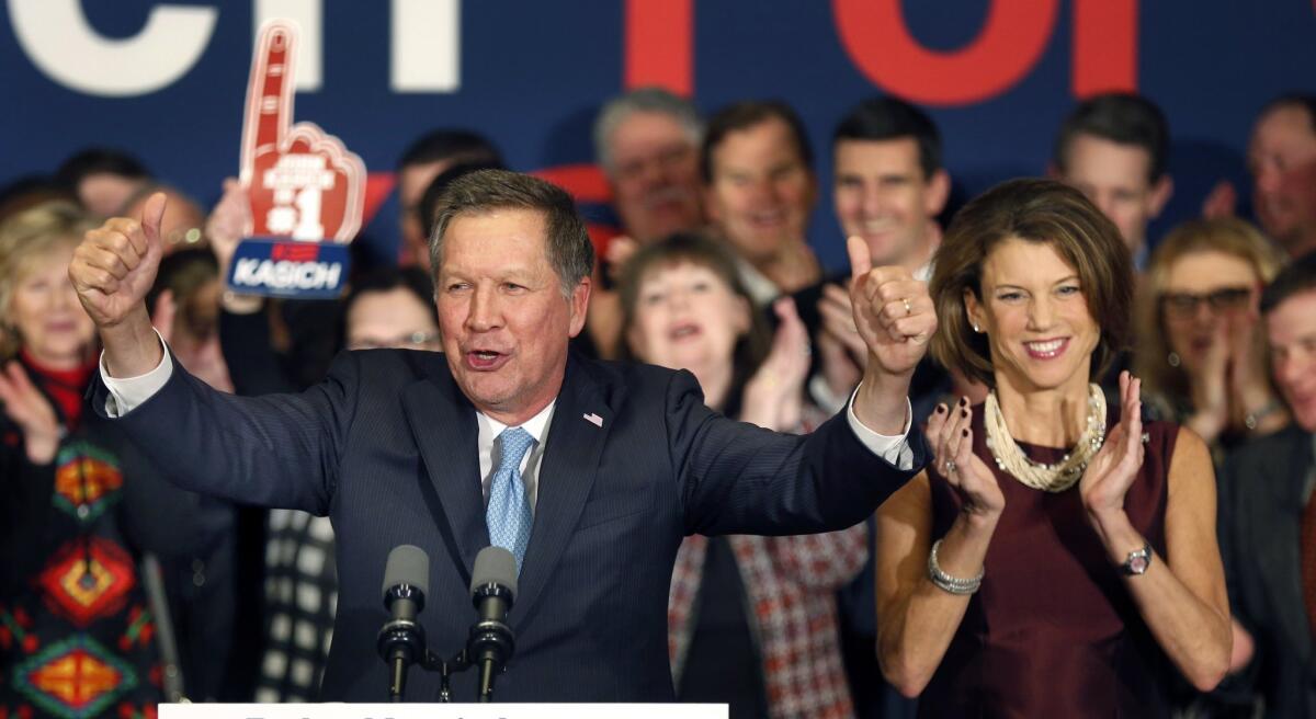 With his wife Karen at his side Republican presidential candidate Gov. John Kasich of Ohio cheers with supporters Tuesday in Concord, N.H., at his primary night rally.
