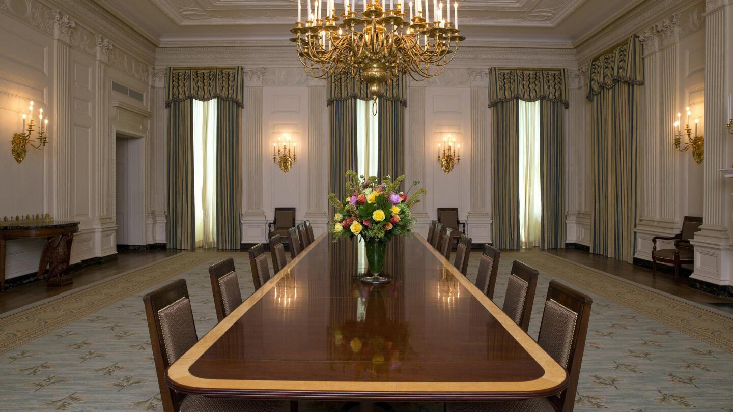 The chairs feature a grid-patterned "horsehair" fabric and are trimmed with brass nail heads.