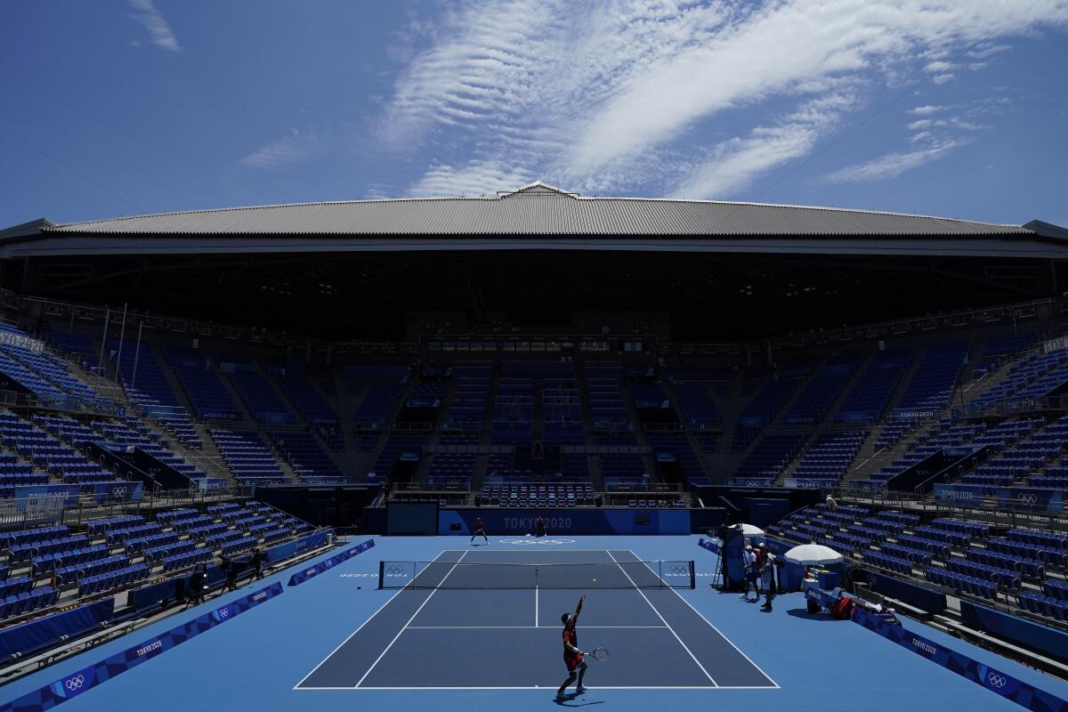 Players practice at the almost empty Ariake Tennis Center.