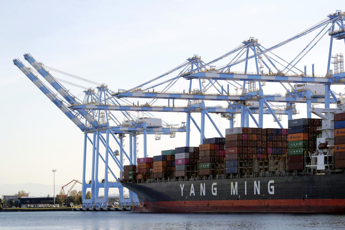 FILE - In this Nov. 4, 2019, file photo, cargo cranes are used to take containers off of a Yang Ming Marine Transport Corporation boat at the Port of Tacoma in Tacoma, Wash. The Commerce Department said Thursday, Jan. 7, 2021, the U.S. trade deficit jumped to $68.1 billion in November as a surge in imports overwhelmed a smaller increase in exports. (AP Photo/Ted S. Warren, File)