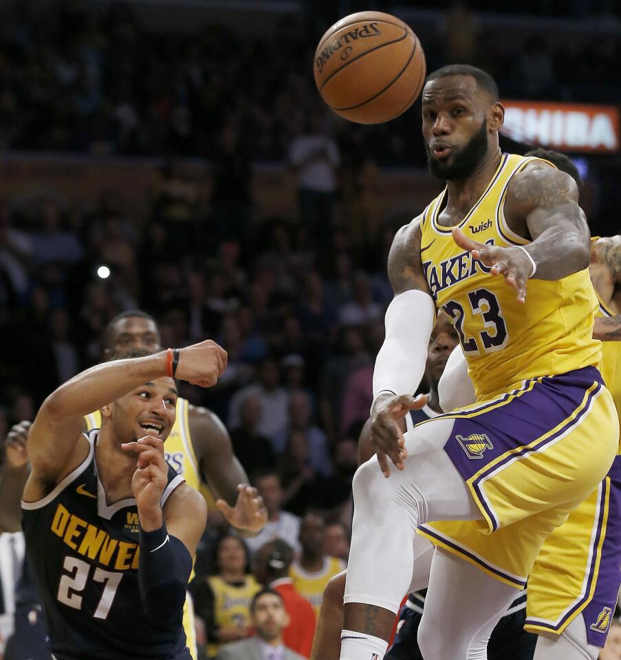 Denver Nuggets guard Jamal Murray, left, passes the ball away from Los Angeles Lakers forward LeBron James, right, during the second half of an NBA basketball game in Los Angeles, Thursday, Oct. 25, 2018. Lakers won 121-114. (AP Photo/Alex Gallardo)