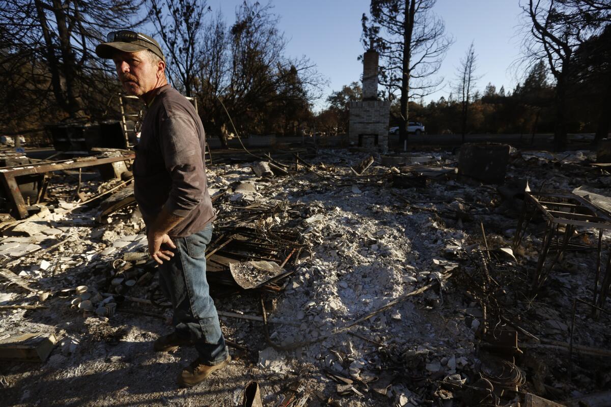Steve Dursteler stands amid the ashes of his Redwood Valley home in Mendocino County.