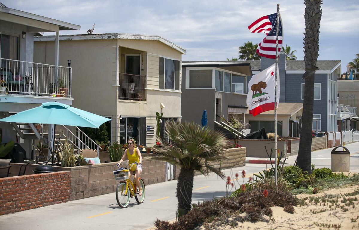 A person bikes past a few houses in Newport Beach.