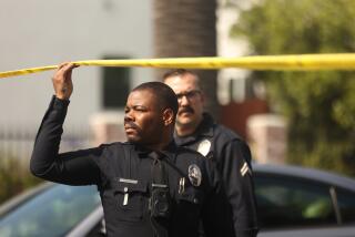 South Los Angeles, CA - June 01: A cops hold up yellow tape from a double homicide shooting in Exposition Park shooting on Saturday, June 1, 2024 in South Los Angeles, CA. (Michael Blackshire / Los Angeles Times)
