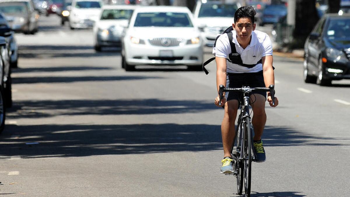 A bicyclist rides his bike along Westwood Boulevard in Westwood. The L.A. City Council on Tuesday approved a sweeping transportation plan that includes adding hundreds of miles of new bicycle lanes on streets.