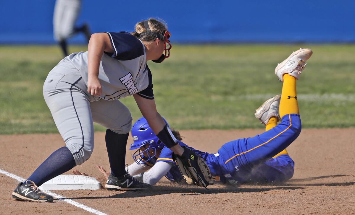 Fountain Valley's Marissa Sardinas (7) slides in under the tag of Newport Harbor third baseman Kori Villeneuve on March 29.