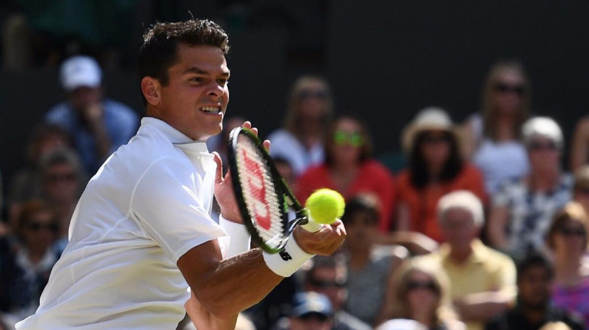 Milos Raonic returns to Andy Murray during their men's singles final match at Wimbledon on July 10.