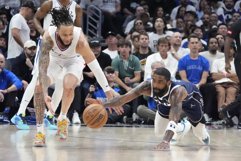 Los Angeles Clippers guard Amir Coffey, left, and Dallas Mavericks guard Kyrie Irving go after a loose ball during the second half in Game 5 of an NBA basketball first-round playoff series Wednesday, May 1, 2024, in Los Angeles. (AP Photo/Mark J. Terrill)