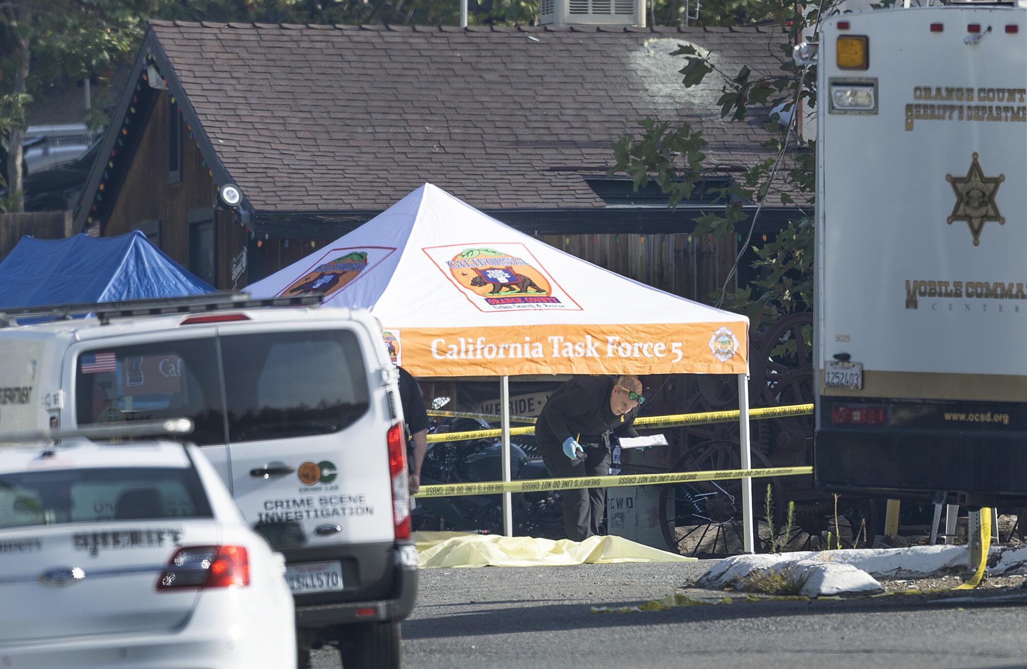 A tarp covers a body at a shooting scene.