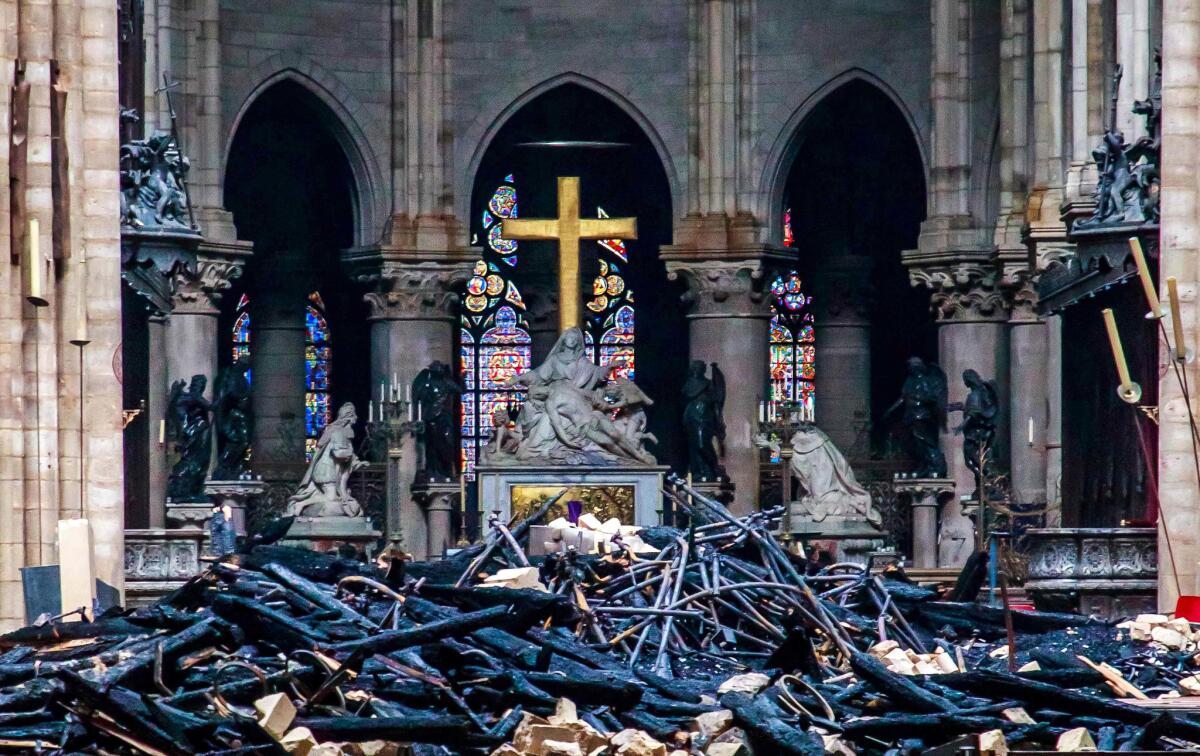 A combination of two pictures made shows the heart and transept at Notre Dame cathedral in Paris before and after the fire.