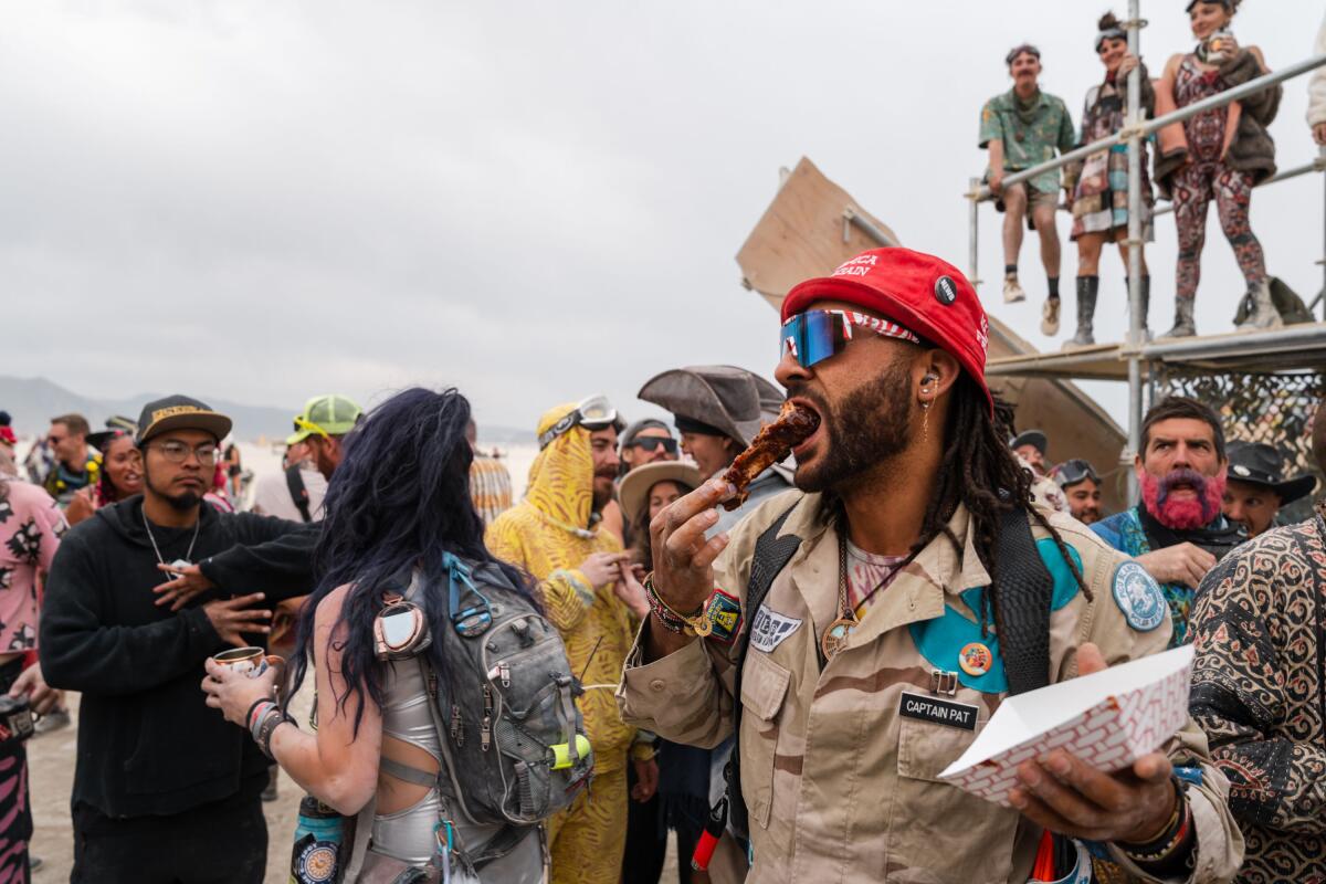 Burning Man reveler chows down among other people