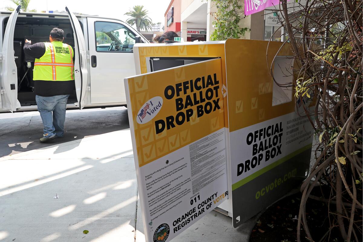 Elections workers swap out one empty bin with another in Huntington Beach in 2021.