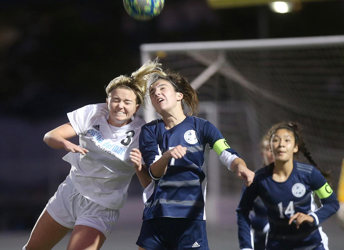 Corona del Mar's Megan Chelf, left, and Newport Harbor's Sadie Pitchess, center, battle for a throw-in during the Battle of the Bay rivalry match on Thursday at Davidson Field.