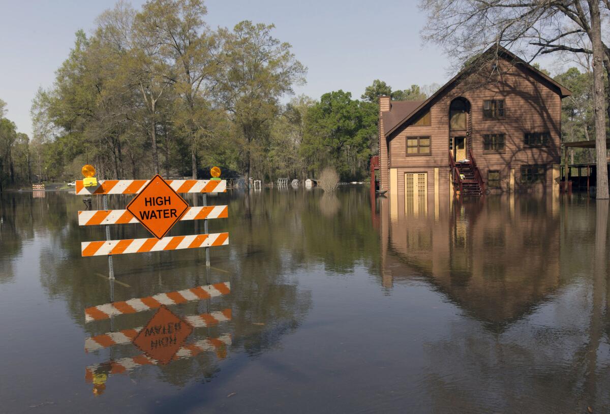 A sign marks high water in a flooded section of Oil City, La.